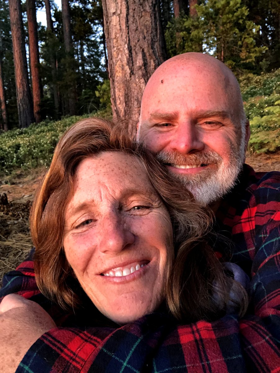 Heidi and Michael smiling together among the pines