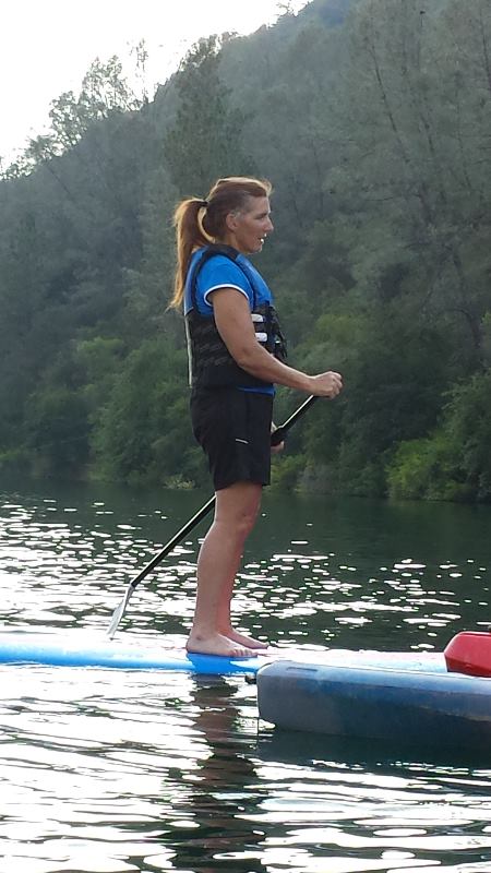 Heidi paddleboarding on a lake